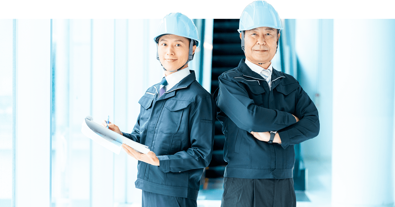 作業服姿の社員が笑顔で立つ様子（会社紹介・アバウト）